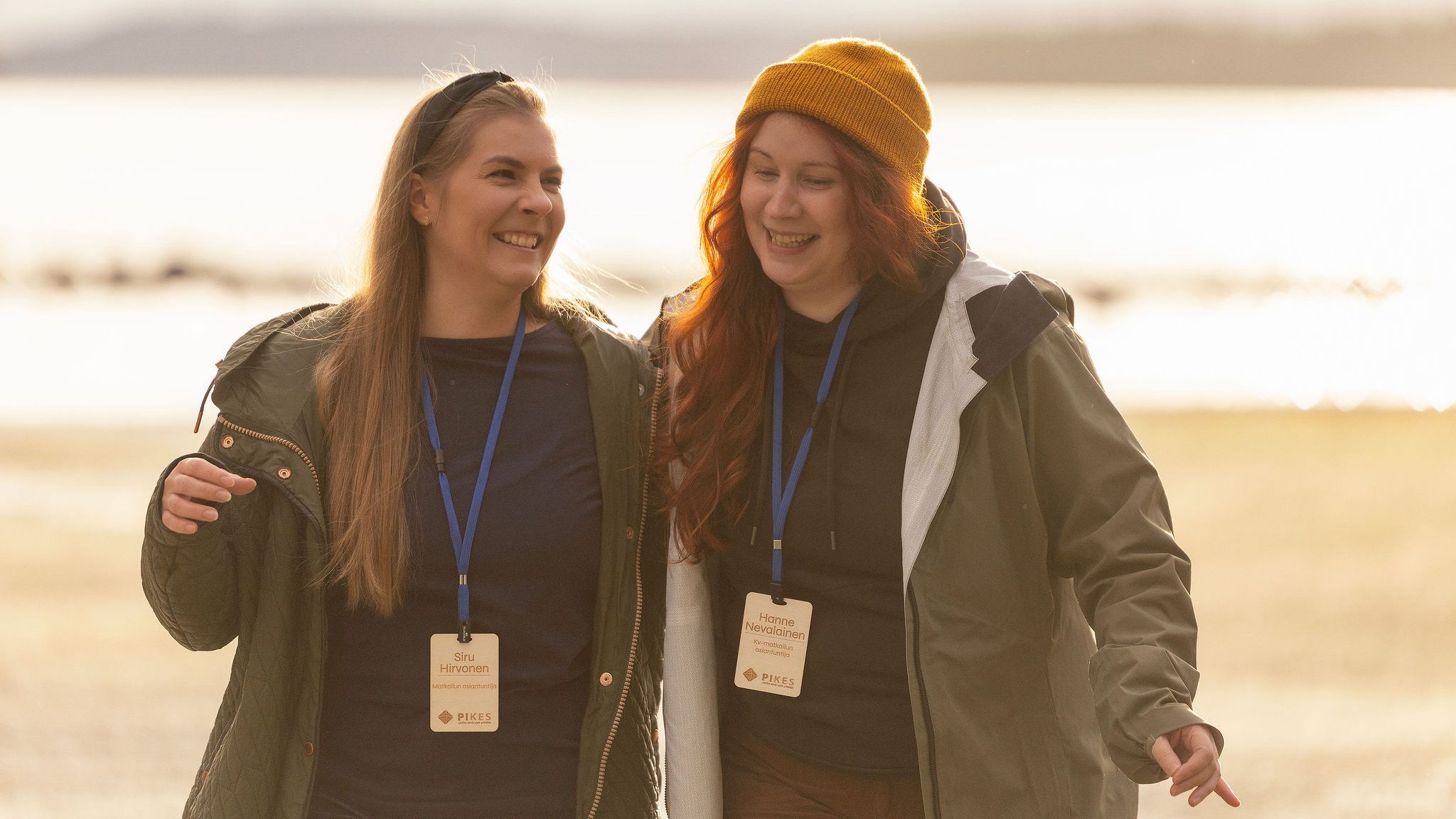 PIKESin Siru Hirvonen ja Hanne Nevalainen aurinkoisessa säässä järven rannalla.