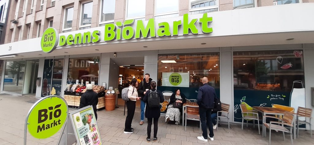 Ihmisiä Denns BioMarkt -kaupan edessä